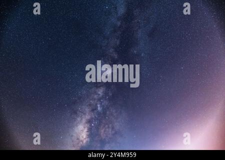 Une vue imprenable sur la voie Lactée qui s’étend à travers le ciel nocturne au-dessus d’une mer calme. La bande étoilée de notre galaxie est visible dans toute sa splendeur. Suao Banque D'Images