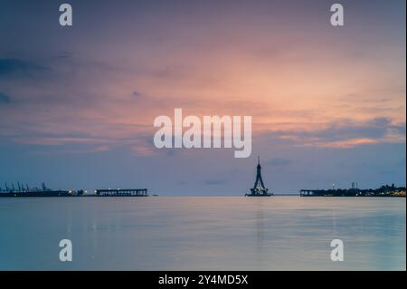 Une silhouette majestueuse du pont Tamsui en construction est baignée dans les teintes dorées du coucher du soleil. La structure inachevée se tient haute contre un V. Banque D'Images