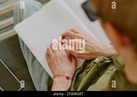 Mains pâles de l'homme méconnaissable avec un handicap sur la page blanche de neige avec des points, haut vers le bas plan Banque D'Images
