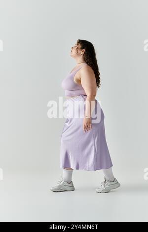 Une femme élégante de grande taille marche avec confiance, mettant en valeur sa beauté et son style. Banque D'Images