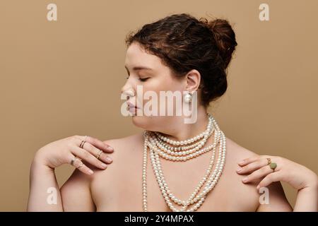 Une superbe femme grande taille met en valeur sa beauté, gracieusement ornée de couches de perles. Banque D'Images