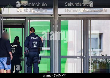 19 septembre 2024, Rhénanie-du-Nord-Westphalie, Duisbourg : des policiers pénètrent dans le bâtiment avec le concierge de l'école polyvalente Duisburg Mitte à Neudorf. Deux écolières de l'école ont été tuées dans un accident de la route sur la côte méditerranéenne de la Toscane. Les deux adolescents - nés en 2005 et 2006 - ont été heurtés par la voiture d'une femme de 44 ans sur la plage du Lido di Camaiore, qui a croisé un groupe de piétons pour des raisons initialement inexpliquées. Selon la police italienne, un total de sept personnes ont été blessées. Photo : Christoph Reichwein/dpa - ATTENTION : personne(s) a/ont été pixel Banque D'Images