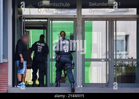 19 septembre 2024, Rhénanie-du-Nord-Westphalie, Duisbourg : des policiers pénètrent dans le bâtiment avec le concierge de l'école polyvalente Duisburg Mitte à Neudorf. Deux écolières de l'école ont été tuées dans un accident de la route sur la côte méditerranéenne de la Toscane. Les deux adolescents - nés en 2005 et 2006 - ont été heurtés par la voiture d'une femme de 44 ans sur la plage du Lido di Camaiore, qui a croisé un groupe de piétons pour des raisons initialement inexpliquées. Selon la police italienne, un total de sept personnes ont été blessées. Photo : Christoph Reichwein/dpa - ATTENTION : personne(s) a/ont été pixel Banque D'Images