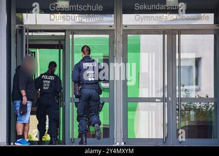 19 septembre 2024, Rhénanie-du-Nord-Westphalie, Duisbourg : des policiers pénètrent dans le bâtiment avec le concierge de l'école polyvalente Duisburg Mitte à Neudorf. Deux écolières de l'école ont été tuées dans un accident de la route sur la côte méditerranéenne de la Toscane. Les deux adolescents - nés en 2005 et 2006 - ont été heurtés par la voiture d'une femme de 44 ans sur la plage du Lido di Camaiore, qui a croisé un groupe de piétons pour des raisons initialement inexpliquées. Selon la police italienne, un total de sept personnes ont été blessées. Photo : Christoph Reichwein/dpa - ATTENTION : personne(s) a/ont été pixel Banque D'Images