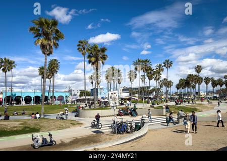 Venice Beach, États-Unis - 31 mars 2024 : des personnes accidentelles sur la promenade corsée à Ocean Front Walk par une journée ensoleillée au printemps contre le ciel bleu avec des nuages Banque D'Images