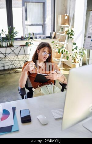 Une jeune personne non binaire est en train de brainstormer des idées tout en étant assis à un bureau élégant. Banque D'Images