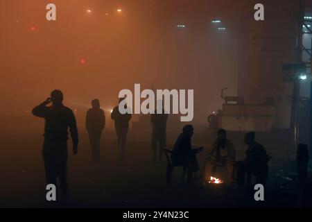 Agra, Uttar Pradesh / Inde - 22 novembre 2011 : Une vue en silhouette des gens dans la rue la nuit en saison hivernale brumeuse. Banque D'Images