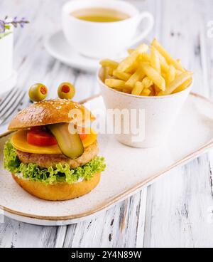 mini hamburger montre la langue. Le concept d'un hamburger préféré des enfants. Banque D'Images
