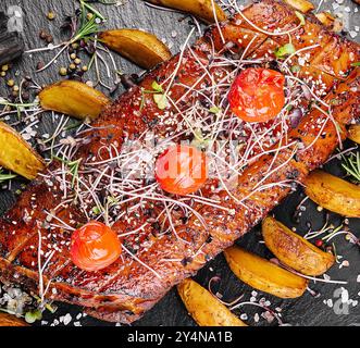 Savoureux filet de porc cuit au four dans un glaçage miel-orange avec des quartiers de pommes de terre Banque D'Images