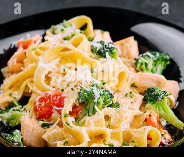 plat italien de pâtes fettuccine alfredo avec saumon grillé et brocoli Banque D'Images