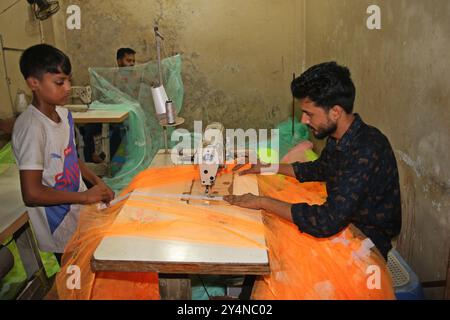 Dhaka. 19 septembre 2024. Des travailleurs fabriquent des moustiquaires dans un marché de Dhaka, Bangladesh, le 18 septembre 2024. La mousson de juin à septembre est la saison de pointe pour la dengue au Bangladesh, un pays à haut risque sujet à la maladie transmise par les moustiques. Au milieu de l'épidémie de dengue, la demande de moustiquaires a considérablement augmenté. Crédit : Xinhua/Alamy Live News Banque D'Images