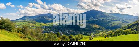 panorama de paysage rural dans les montagnes des carpates en automne. journée ensoleillée. champ herbeux et collines ondulantes. paysage de campagne de l'ukraine. village en t Banque D'Images
