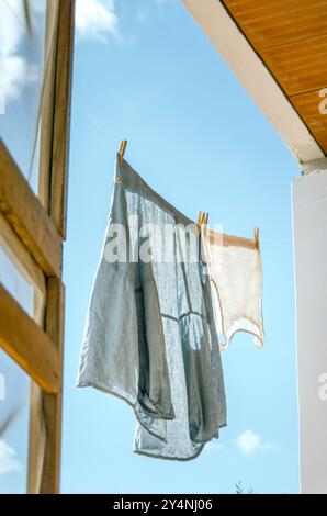 Chemise en lin et haut séchage à l'air sur une corde à linge au soleil Banque D'Images