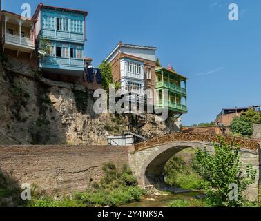 Escalier en colimaçon des maisons géorgiennes traditionnelles avec balcons en bois sculpté au canyon de Leghvtakhevi, et le pont en pierre gracieux avec serrure d'amour Banque D'Images