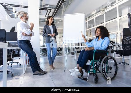 Femme exécutive handicapée en fauteuil roulant au bureau donnant une présentation sur la stratégie Banque D'Images