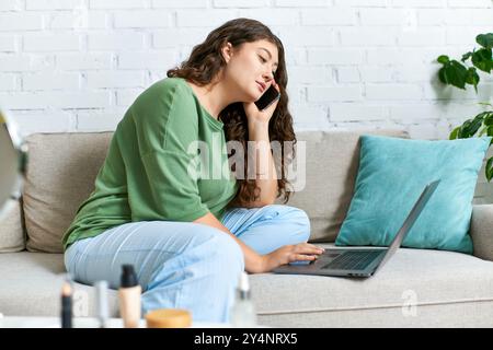 Une femme de grande taille apprécie sa routine beauté, parlant au téléphone tout en étant confortablement assise dans son salon. Banque D'Images