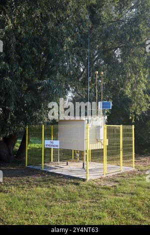 Point de régulation et de distribution de gaz naturel avec batterie solaire près de la forêt jour ensoleillé. Injection de gaz dans le plan vertical de l'armoire du consommateur. Texte russe - Banque D'Images