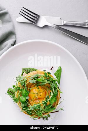 Bagel au saumon salé, épinards, avocat et oeuf dur mou au jaune liquide Banque D'Images