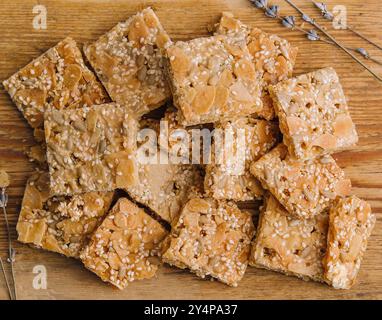 Barres de carrés croquants de céréales multigrains avec des graines de citrouille sur fond en bois Banque D'Images