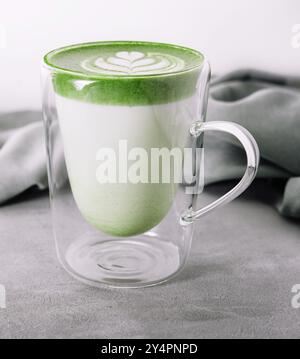 Verre de latte de thé vert matcha chaud avec motif tulipe Banque D'Images