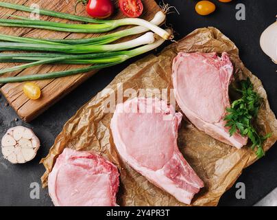 Plusieurs steaks de porc crus sur du papier cuisson Banque D'Images