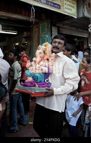 Mumbai, Maharashtra / Inde - 15 septembre 2007 : Un homme portant la statue du Seigneur Shree Ganesha pendant la fête de Ganesha. Banque D'Images