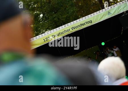 Heilbad Heiligenstadt, Allemagne. 19 septembre 2024. Les amateurs de randonnée s'assoient devant une scène lors de la 122ème Journée allemande de randonnée 2024. La Journée allemande de la randonnée est un rassemblement annuel de passionnés de randonnée et a lieu du 19 au 22 septembre 2024. Crédit : Swen Pförtner/dpa/Alamy Live News Banque D'Images