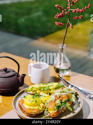 Œufs bénédictés sur muffin anglais avec saumon fumé, mélange de salade de laitue et sauce hollandaise Banque D'Images