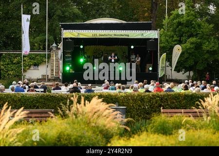 Heilbad Heiligenstadt, Allemagne. 19 septembre 2024. Les amateurs de randonnée s'assoient devant une scène lors de la 122ème Journée allemande de randonnée 2024. La Journée allemande de la randonnée est un rassemblement annuel de passionnés de randonnée et a lieu du 19 au 22 septembre 2024. Crédit : Swen Pförtner/dpa/Alamy Live News Banque D'Images