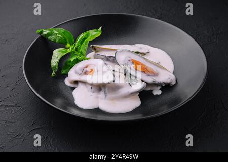 moules dans une sauce crémeuse au fromage bleu et basilic Banque D'Images