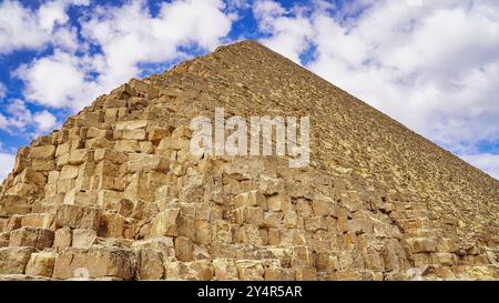 Une vue ascendante depuis la base de la Grande Pyramide de Khufu avec ses énormes blocs de calcaire tura contre un ciel bleu brillant sur le plateau de Gizeh Banque D'Images