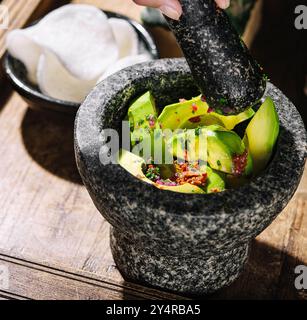 Guacamole dans un mortier avec des copeaux de riz Banque D'Images