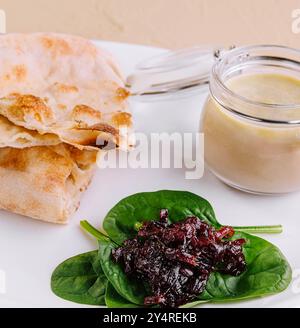 pâté de poulet avec confiture d'oignons et pain pita servi dans une assiette blanche Banque D'Images