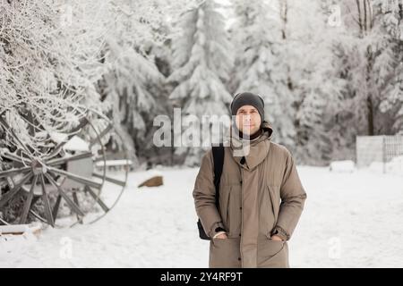 Portrait d'un jeune homme en vêtements chauds dans la forêt d'hiver. Tourisme. Banque D'Images