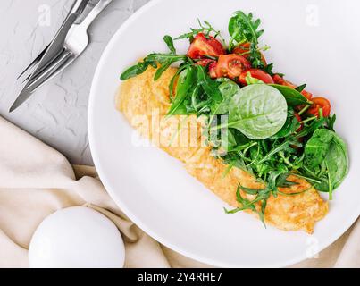 Omelette avec roquette, tomates et basilic dans une assiette Banque D'Images