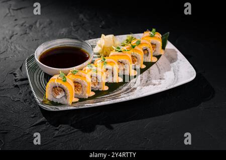 Petits pains de sushi gourmands avec garniture à la mangue, servis avec sauce soja et gingembre sur une assiette chic Banque D'Images