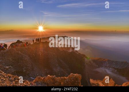 Les gens sur le sommet du volcan Rinjani regardant le lever du soleil, Lombok, Indonésie, Asie Banque D'Images