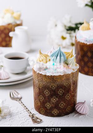 Kulich traditionnel de pâques garni de glaçage pastel et de merengues, servi avec du thé Banque D'Images