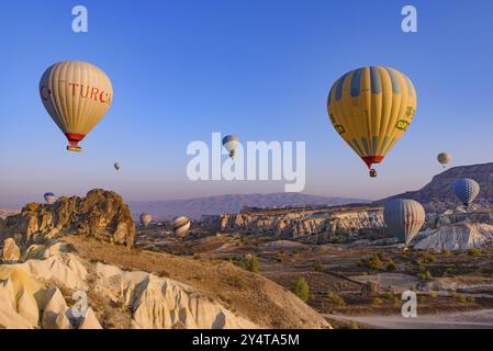 Vol de montgolfières et paysage rocheux à l'heure du lever du soleil à Goreme, Cappadoce, Turquie, Asie Banque D'Images