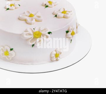 Gâteau blanc exquis et élégant avec fleurs de sucre fondantes faites à la main. Parfait pour un anniversaire ou une célébration de mariage. Une délicieuse pâtisserie gastronomique Banque D'Images