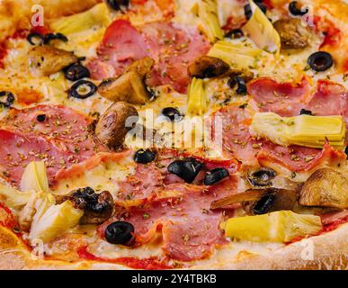 Pizza suprême fraîchement cuite garnie de divers ingrédients gros plan Banque D'Images