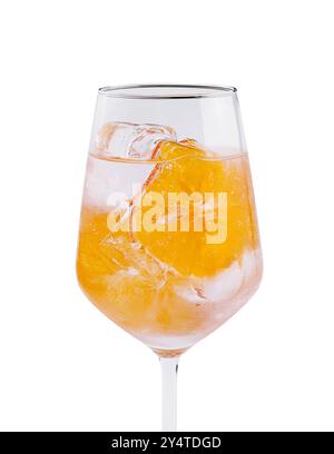 Verre à vin en cristal rempli d'une boisson orange vibrante et de glace, isolé sur blanc Banque D'Images