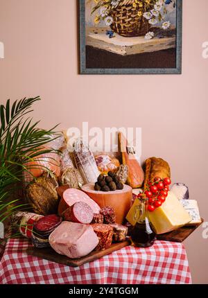 Sélection de fromages fins, de viandes et de pain élégamment agencés sur une nappe à carreaux classique Banque D'Images