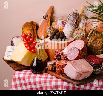 Sélection de fromages fins, de viandes et de pain élégamment agencés sur une nappe à carreaux classique Banque D'Images