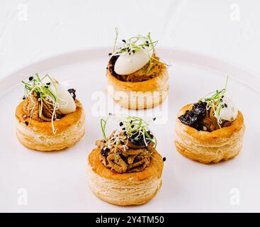 Elégante pâte feuilletée vol-au-vent avec garniture salée, servie sur une assiette blanche immaculée Banque D'Images