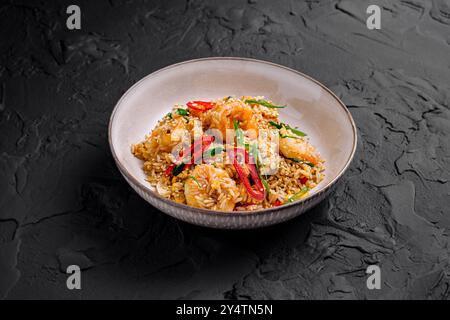 Riz frit servi dans une assiette avec crevettes, piments et oignons verts Banque D'Images