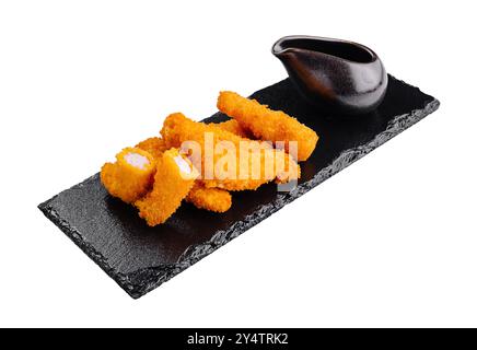 Lanières de poulet panées frites avec sauce trempette servies sur un plateau d'ardoise noire Banque D'Images