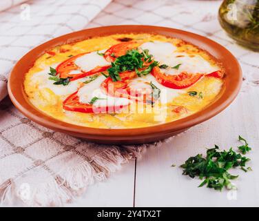 Délicieux gnocchi italiens avec mozzarella et tomates servis sur une table rustique en bois blanc Banque D'Images