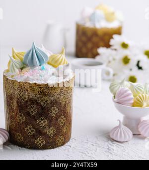 Gâteau traditionnel kulich de pâques garni de meringues pastel et de saupoudrées, au décor festif Banque D'Images