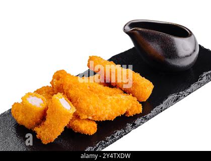 Lanières de poulet panées frites avec sauce trempette servies sur un plateau d'ardoise noire Banque D'Images